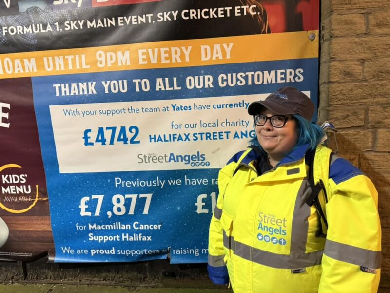 Halifax Street Angel Stood in front of a fundraising poster.